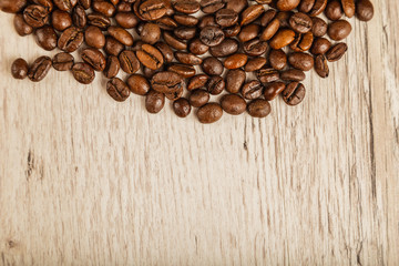 Grains of coffee on a wooden background in large quantities