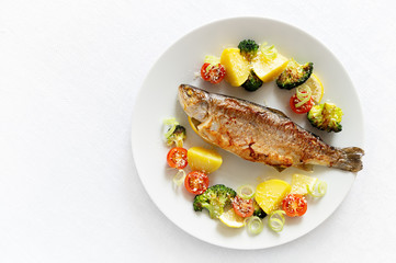 trout with potato, broccoli, cherry tomatoes, lemon, and leek sprinkled with parmesan