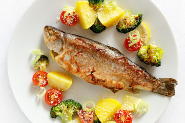 fried fish stuffed with lemon and leek served with potato, broccoli, cherry tomatoes, lemon, and leek sprinkled with parmesan