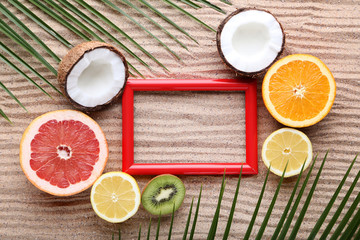 Red frame with different fruits on wooden table