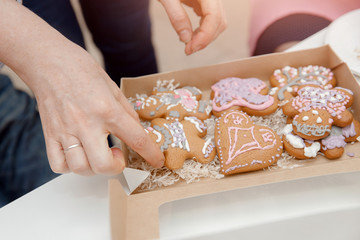 Decorating gingerbread cakes color glaze, girl showing cookies