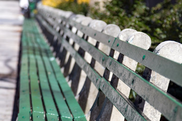 Sunlight shines on empty park bench in Manhattan, New York City