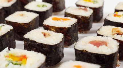 Traditional sushi with salmon, tuna , eel and vegetables on a white background close up.