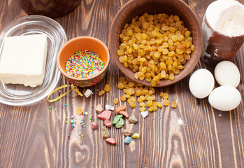 Close up of colorful Easter eggs and bowl of raisins for cakes. Easter concept.