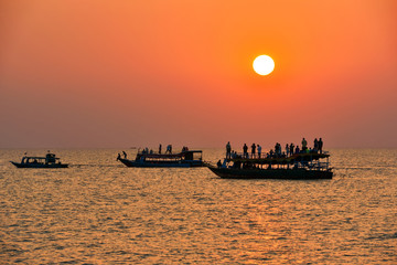 Obraz premium Tourists watch sunset at Tonle Sap lake(komprongpok),landmark of Cambodia.