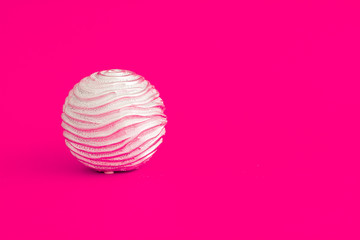 Fototapeta na wymiar Decorative Silver Sphere with Irregular Spiral Pattern on Pink