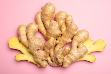 Trendy food flat lay concept on light pink background with fresh big ginger root close up copy...