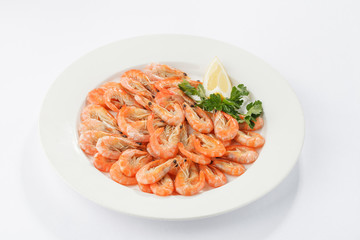 Boiled shrimps on white plate with lemon