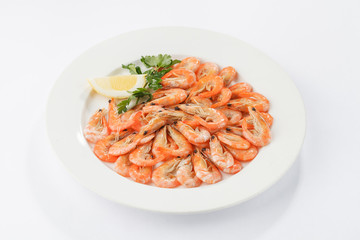 Boiled shrimps on white plate with lemon