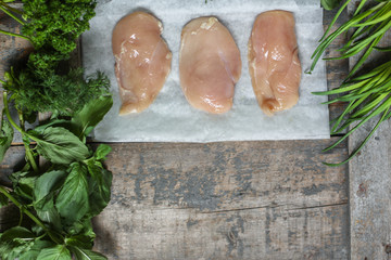 raw chicken breast (a piece of meat) - fresh foods and herbs - useful cuisine.  Food background