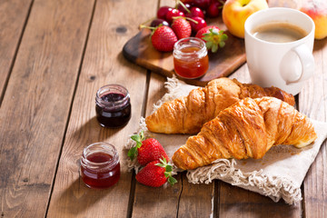 breakfast with croissants, coffee and fresh fruits