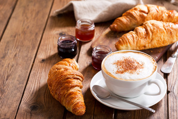 Breakfast with cup of cappuccino coffee with croissants - obrazy, fototapety, plakaty