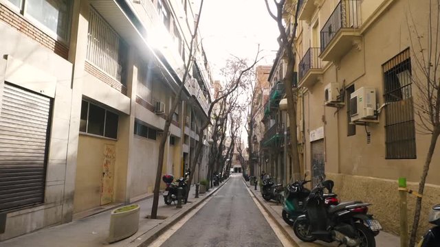 Narrow pedestrian greek street between old buildings in Lefkada town, Greece. Stock. Narrow street between houses with motorcycles