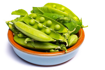 Fresh green ripe sugar snaps, sweet peas in bowl copy space close up isolated on white background