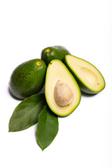 Fresh organic ripe green whole and sliced Fuerte avocado with leaves, copy space close up isolated on white background