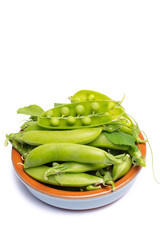 Fresh green ripe sugar snaps, sweet peas in bowl copy space close up isolated on white background