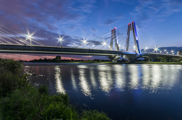 Fototapeta na wymiar modern bridge over Vistula river, Krakow, Poland, illuminated in the night