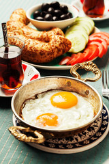 Traditional Turkish breakfast with fried eggs and tea