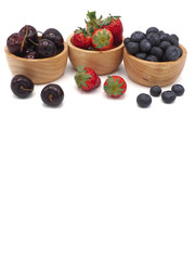 Fresh summer fruits, Cherry, strawberry, and blueberry in wooden bowl isolated on white background.