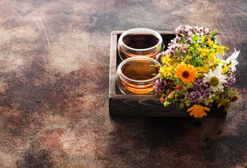 Obraz na płótnie Canvas Cups Herbal tea and Healing herbs in a wooden tray. Herbal medicine