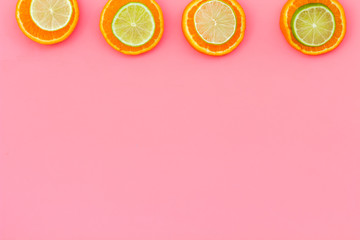 Citrus frame. Oranges and lime round slices composition on pink background top view copy space