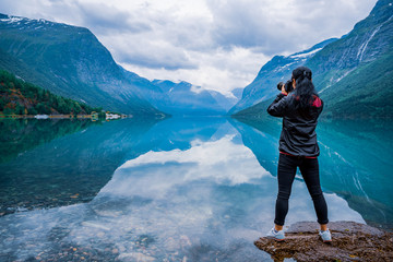 Nature photographer tourist with camera shoots lovatnet lake Beautiful Nature Norway.