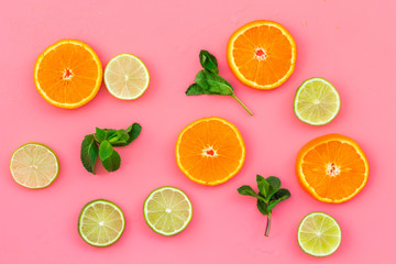 Fruit pattern. Oranges and lime round slices composition on pink background top view