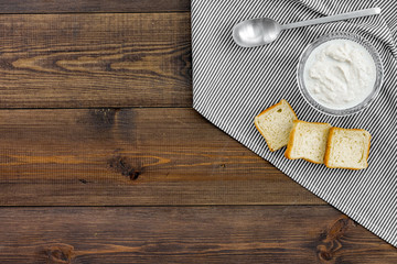 Healthy meal. White mushroom cream soup served with rusks on dark wooden background top view copy space