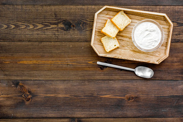 Healthy meal. White mushroom cream soup served with rusks on dark wooden background top view copy space