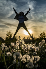 Young happy girl jumping at sunset