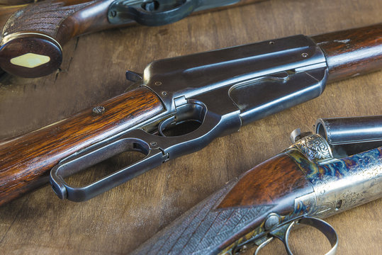Beautiful hunting gun on wooden background close up, selective focus
