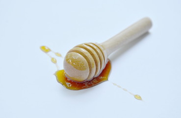 wooden honey scoop on white background