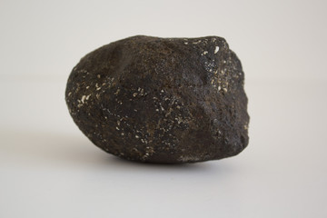 black rock on white background stone black earthy tones stone texture rough photo background