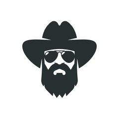 Bearded cowboy in sunglasses and in a hat. Cool American man