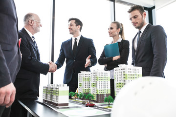 Business people standing near houses models