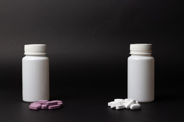 two white bottles stand on a black background, next to them lie a pile of tablets, white and purple
