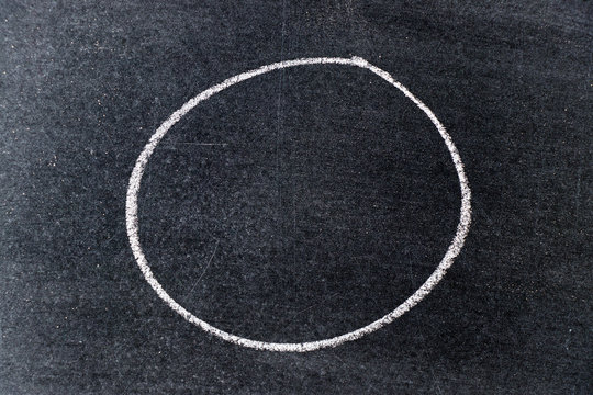 White chalk drawing in circle shape on black board background