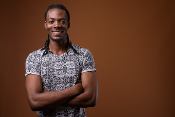 Young handsome African man against brown background