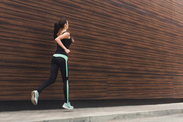 Young woman running in city copy space