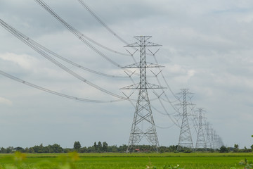 High-voltage Electrical poles with blue sky and green fields