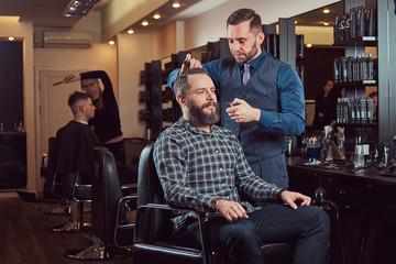 Professional barber working with a client in a hairdressing salon.