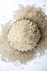 Indian special most popular uncooked Basmati long grained with a unique aroma in a clay bowl isolated on white.