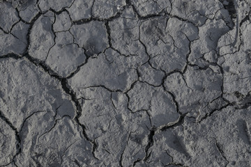 Drought. Cracks in the dry ground. Natural grey background