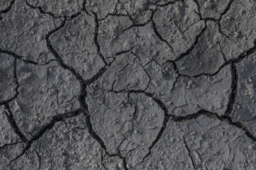 Drought. Cracks in the dry ground. Natural grey background