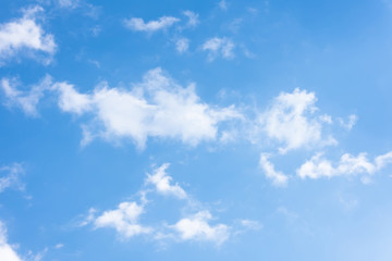 Blue sky with torn white formless clouds.