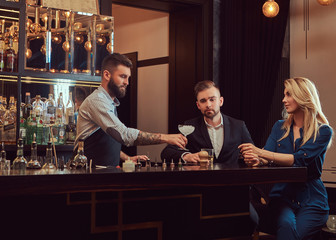 Stylish brutal barman serves an attractive couple who spend an evening on a date.