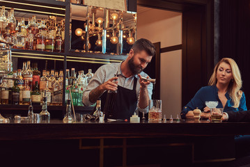 Stylish brutal barman serves an attractive couple who spend an evening on a date.