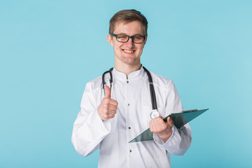 Medical doctor writing prescription over blue background showing thumbs up