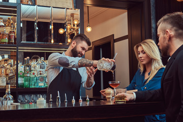 Stylish brutal barman serves an attractive couple who spend an evening on a date.