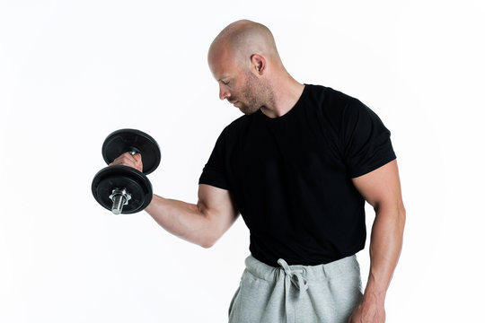 Athletic body builder pumping up muscles with dumbbells on white background